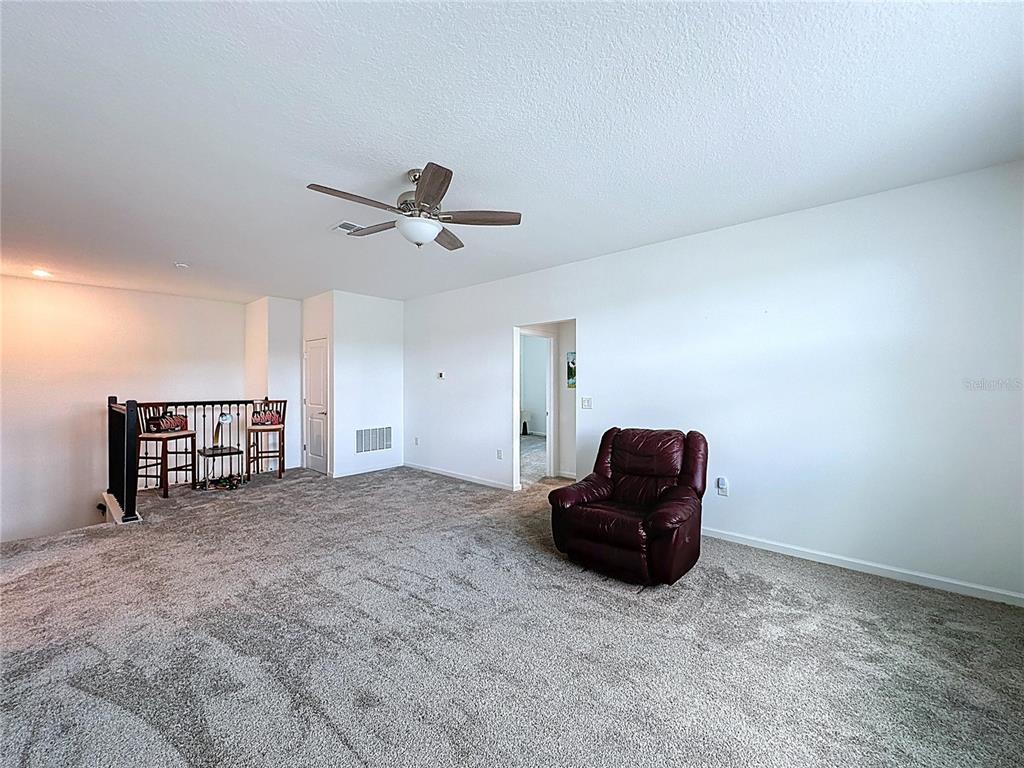 4190 Bull Street St. Cloud, FL 34772 - Photo 56 of 98 a living room with a ceiling fan and a window