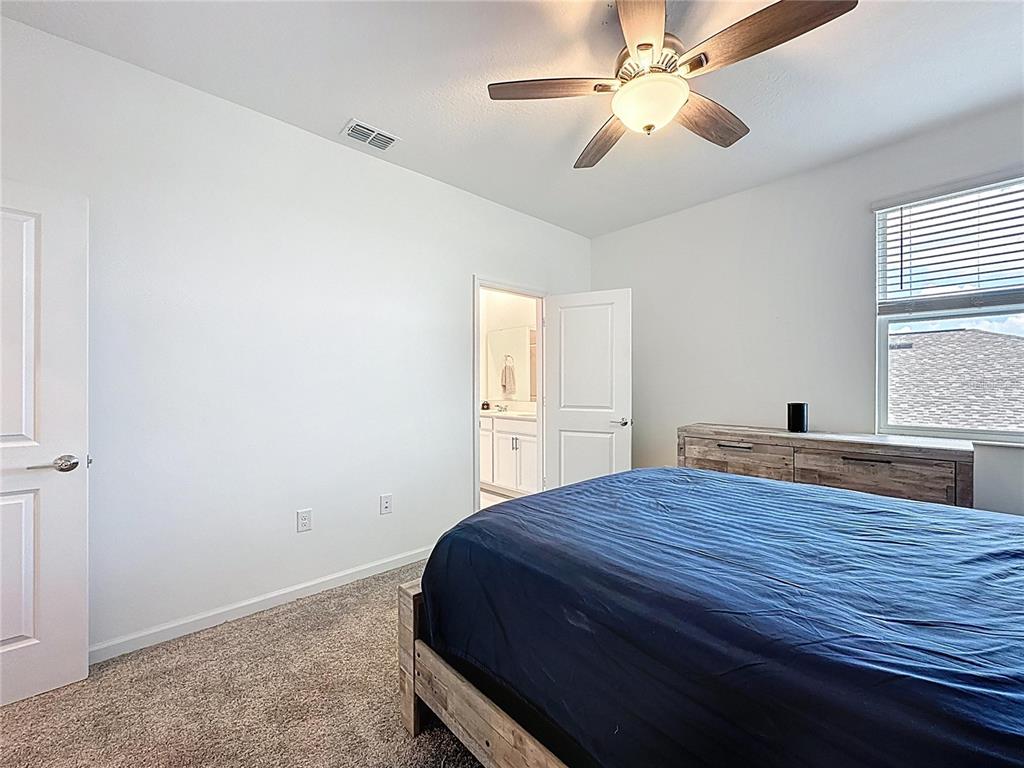 4190 Bull Street St. Cloud, FL 34772 - Photo 59 of 98 a bedroom with a bed and a chandelier