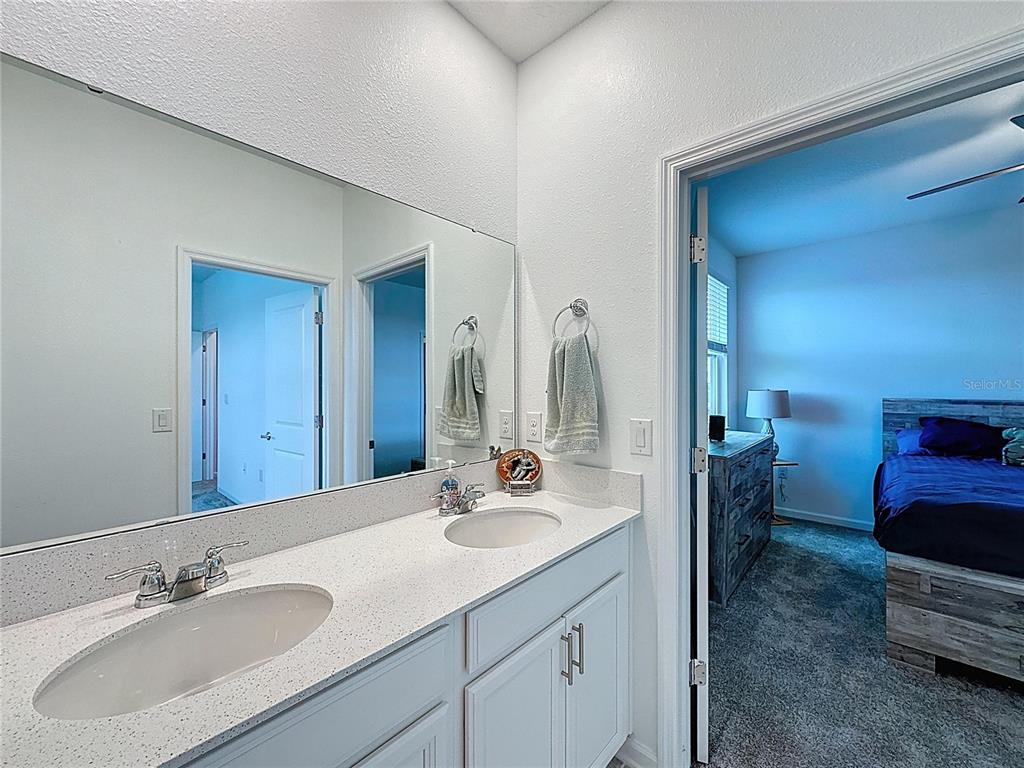 4190 Bull Street St. Cloud, FL 34772 - Photo 75 of 98 a en suite bathroom with a double vanity sink and a mirror
