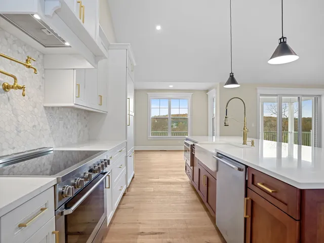 a kitchen with cabinets appliances and wooden floor
