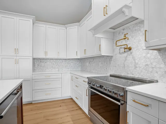 a kitchen with kitchen island granite countertop a sink a counter top space and stainless steel appliances