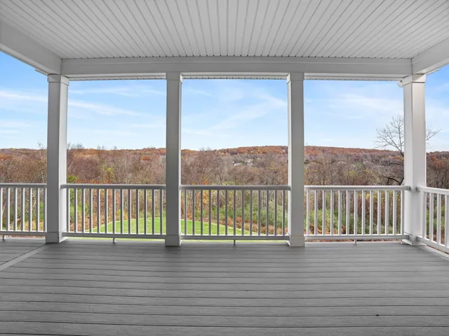 a view of a porch with wooden floor and floor to ceiling window