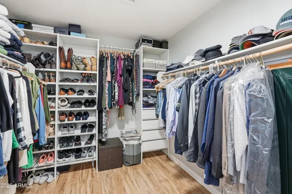 a view of walk in closet with clothes and shoes