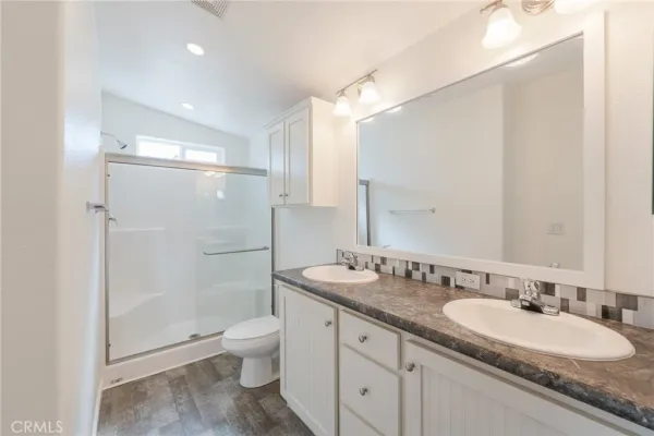 a bathroom with a granite countertop shower sink double and mirror