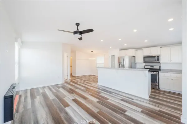 a view of kitchen with stainless steel appliances kitchen island sink and refrigerator
