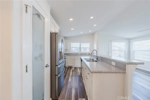 a kitchen with granite countertop kitchen island wooden floor center island and stainless steel appliances