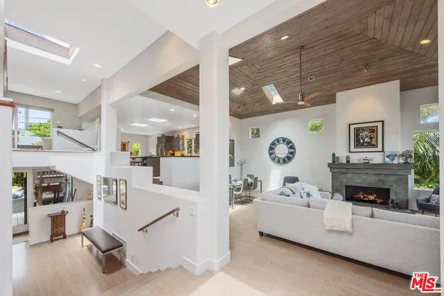 a kitchen with stainless steel appliances granite countertop a table chairs sink and wooden floor