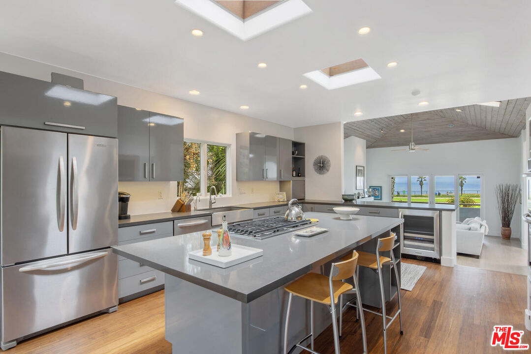 1312 Shoreline Drive Santa Barbara, CA 93109 - Photo 17 of 67 a kitchen with stainless steel appliances granite countertop a table chairs sink and wooden floor