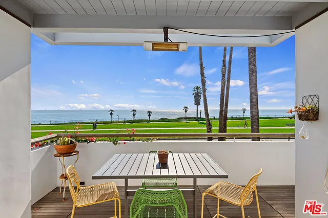 a view of patio with couches table and chairs and potted plants