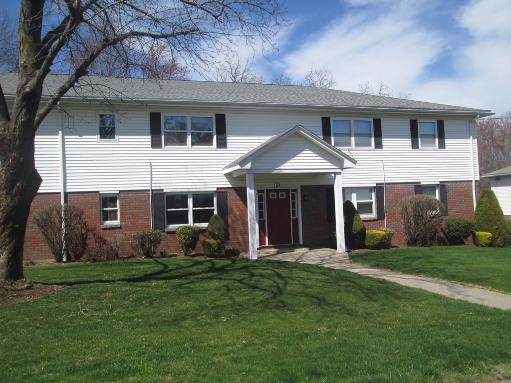 a front view of a house with a garden and yard