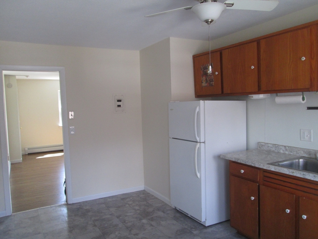 119 Colonial Circle, Unit B Chicopee, MA 01020 - Photo 2 of 17 a kitchen with a refrigerator and cabinets