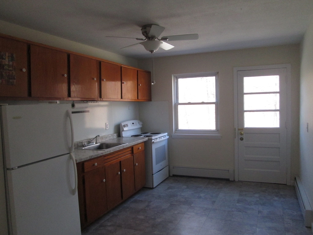 119 Colonial Circle, Unit B Chicopee, MA 01020 - Photo 3 of 17 a kitchen with window wooden cabinets and a sink
