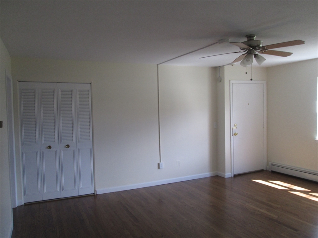119 Colonial Circle, Unit B Chicopee, MA 01020 - Photo 7 of 17 an empty room with wooden floor closet fan and windows