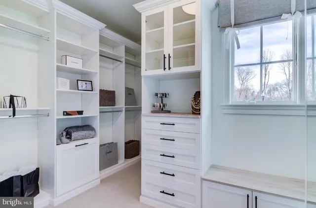 a view of walk in closet with clothes and shoes