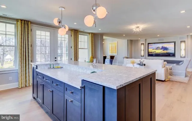 a large kitchen with kitchen island a large island in the center windows and a chandelier