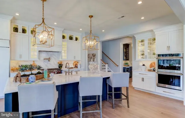 a kitchen with kitchen island a dining table chairs sink and cabinets