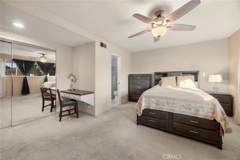 a spacious bedroom with a bed and a table chair