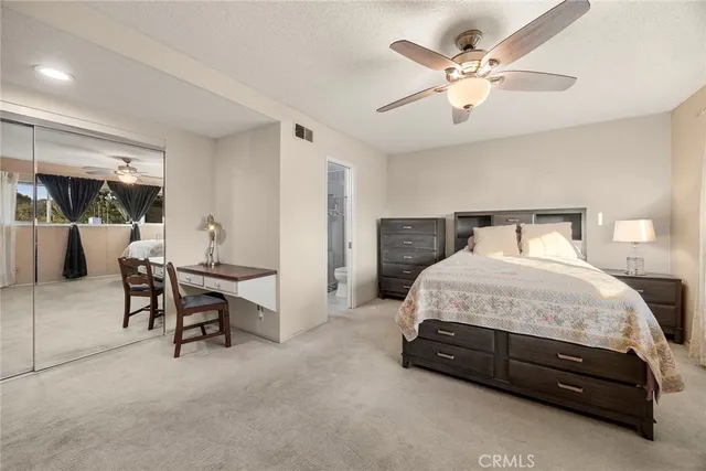 a spacious bedroom with a bed and a table chair