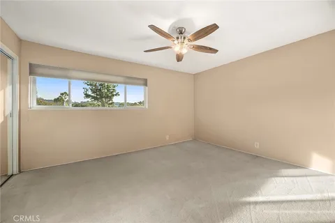 an empty room with windows and fan