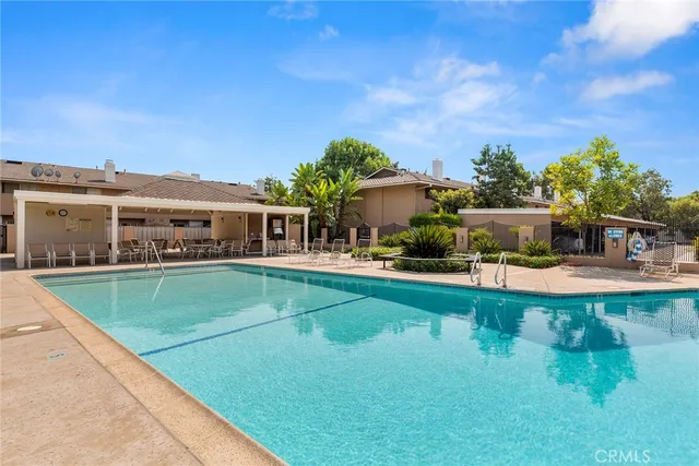 a view of a house with pool and a yard