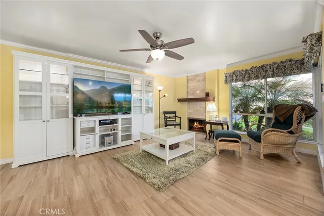 a living room with furniture a flat screen tv and a floor to ceiling window