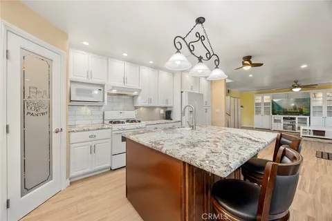 a kitchen with stainless steel appliances granite countertop a sink a stove and a refrigerator