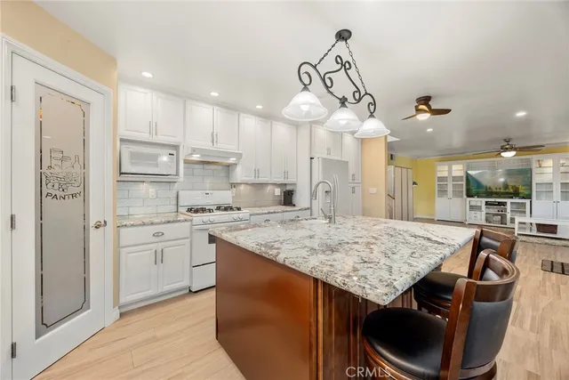 a kitchen with stainless steel appliances granite countertop a sink a stove and a refrigerator