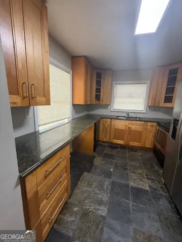 a kitchen with granite countertop a sink and a stove