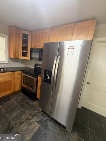 a kitchen with stainless steel appliances a refrigerator a sink a stove a microwave and island