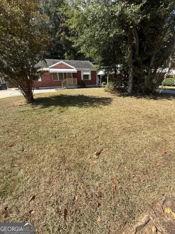 a view of house with yard and swimming pool