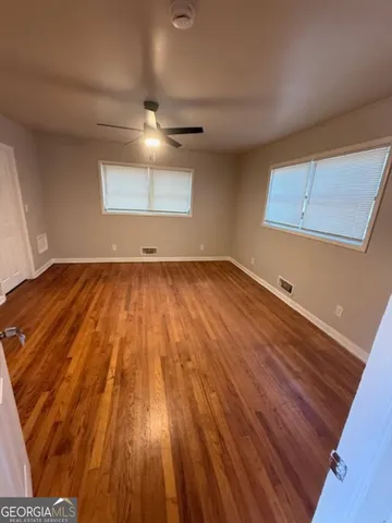 a view of an empty room with wooden floor
