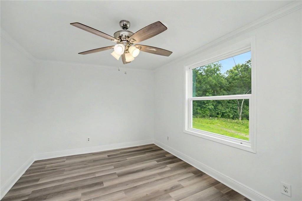 1605 Shackelford Road Griffin, GA 30224 - Photo 22 of 51 an empty room with wooden floor fan and windows