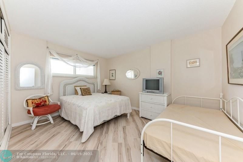 710 North Ocean Boulevard, Unit 1203 Pompano Beach, FL 33062 - Photo 14 of 23 a bedroom with a bed and a lamp on table