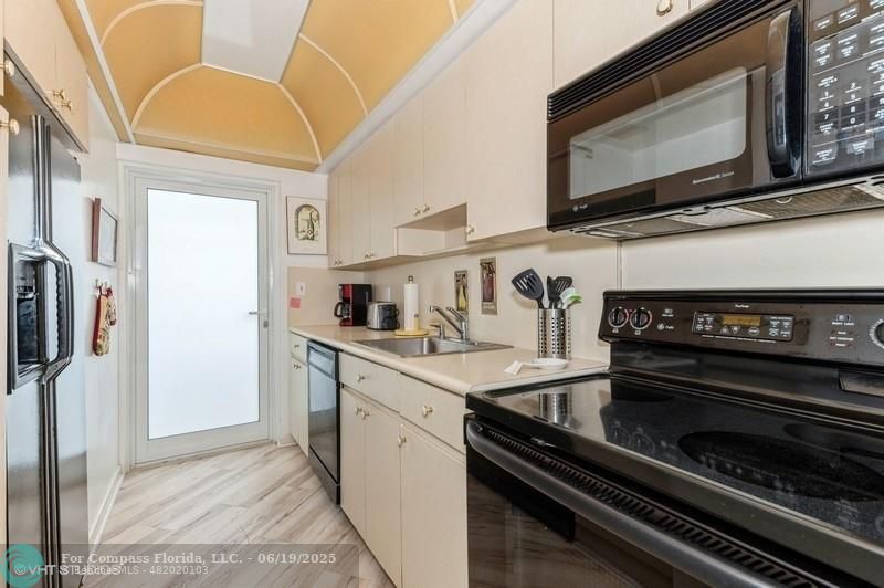 710 North Ocean Boulevard, Unit 1203 Pompano Beach, FL 33062 - Photo 16 of 23 a kitchen with stainless steel appliances a stove a microwave and a sink