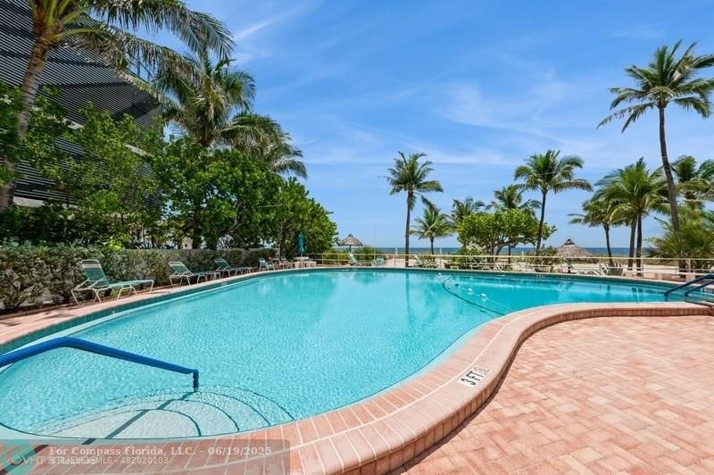 710 North Ocean Boulevard, Unit 1203 Pompano Beach, FL 33062 - Photo 2 of 23 a view of a swimming pool with a table and chairs