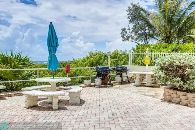 a view of a patio with a dining table and chairs with wooden floor and fence