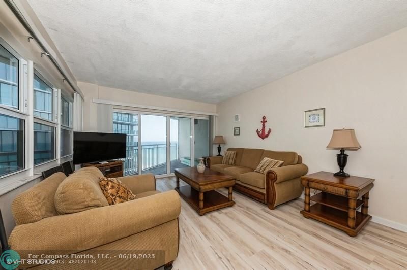 710 North Ocean Boulevard, Unit 1203 Pompano Beach, FL 33062 - Photo 10 of 23 a living room with furniture flat screen tv and a large window