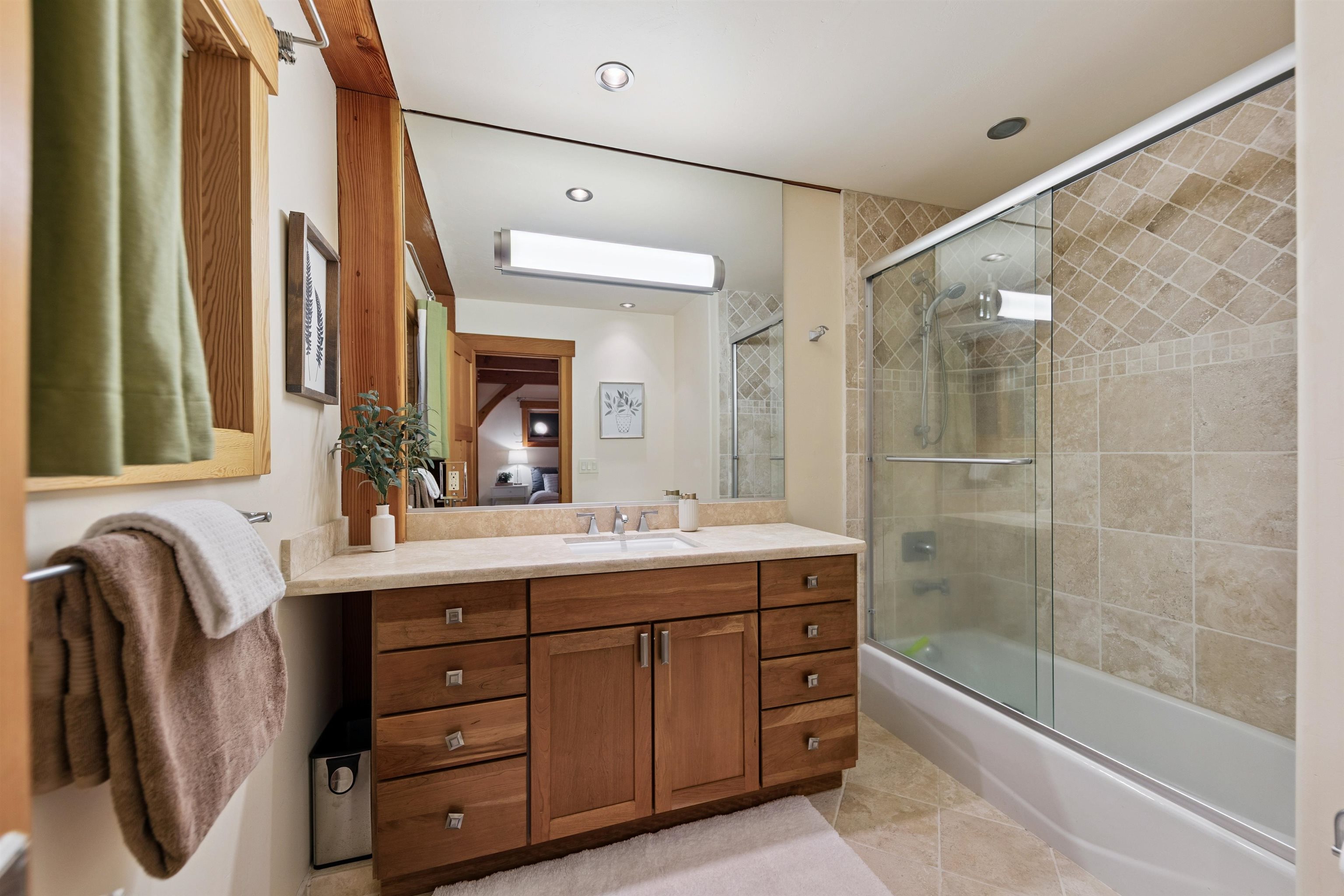 15075 Wolfgang Road Truckee, CA 96161 - Photo 25 of 28 a bathroom with a double vanity sink a large mirror and a bathtub
