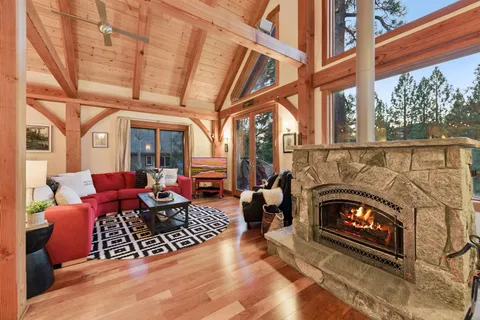 a living room with furniture a fireplace and a floor to ceiling window