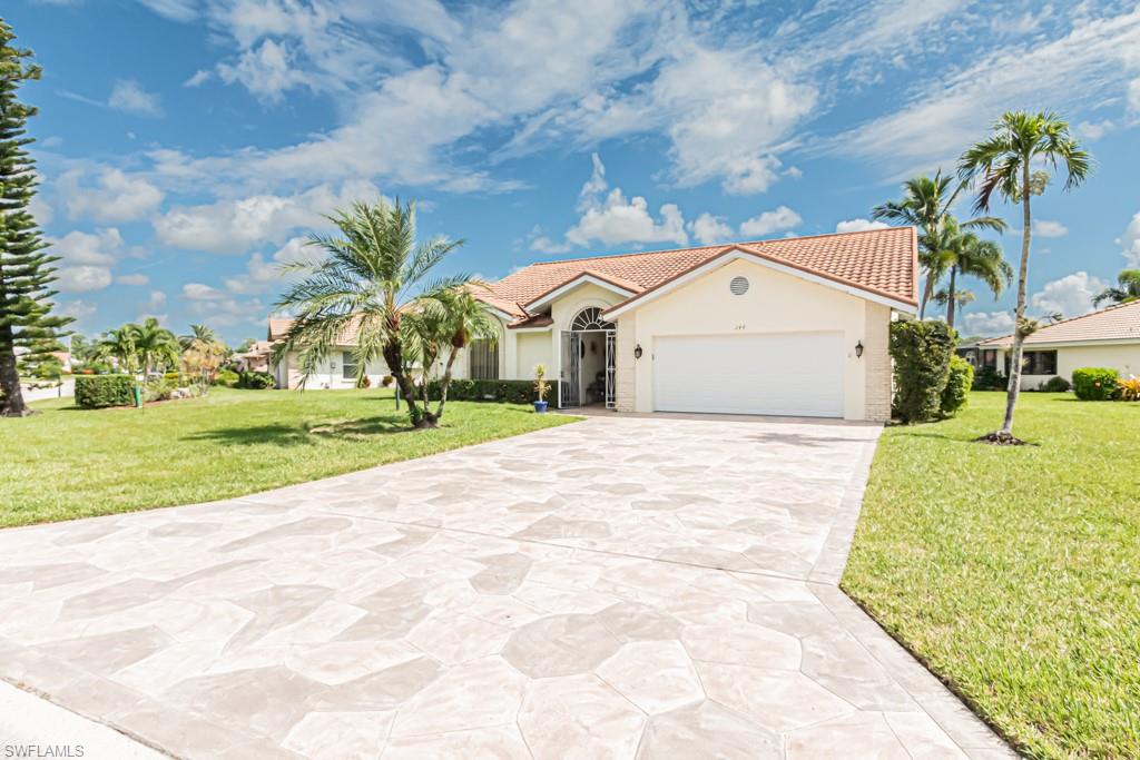 248 St James Way Naples, FL 34104 - Photo 1 of 34 a view of a white house with a big yard and large trees