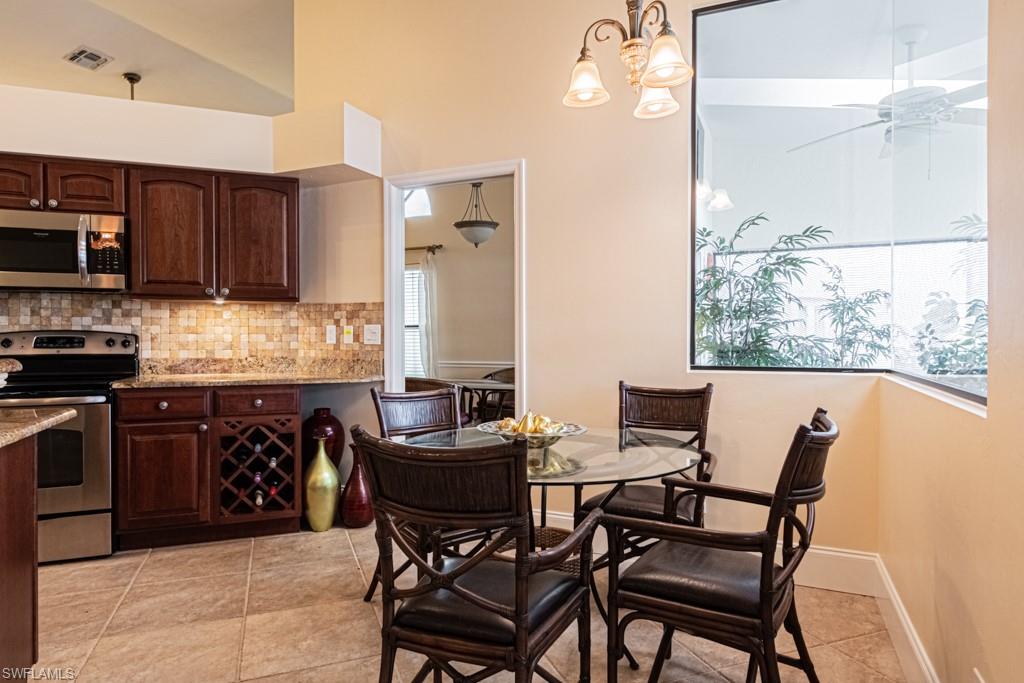 248 St James Way Naples, FL 34104 - Photo 12 of 34 a kitchen with a table chairs and a refrigerator