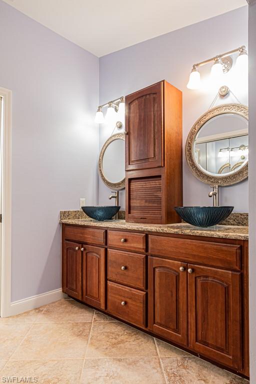 248 St James Way Naples, FL 34104 - Photo 15 of 34 a bathroom with a granite countertop sink and a mirror