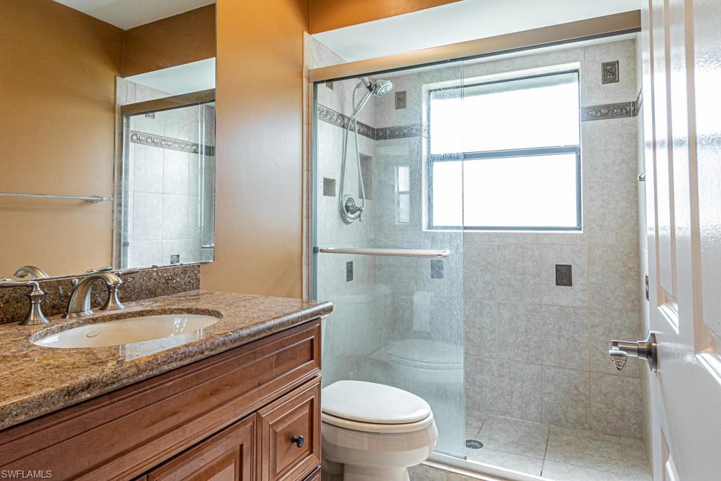 248 St James Way Naples, FL 34104 - Photo 20 of 34 a bathroom with a granite countertop sink toilet and shower