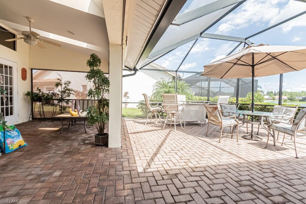 248 St James Way Naples, FL 34104 - Photo 25 of 34 a view of a patio with a dining table and chairs under an umbrella