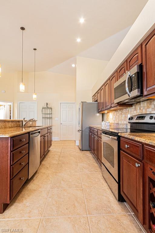 248 St James Way Naples, FL 34104 - Photo 10 of 34 a kitchen with stainless steel appliances granite countertop a stove a sink and a microwave