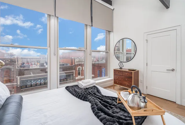 a living room with furniture a fireplace and a floor to ceiling window