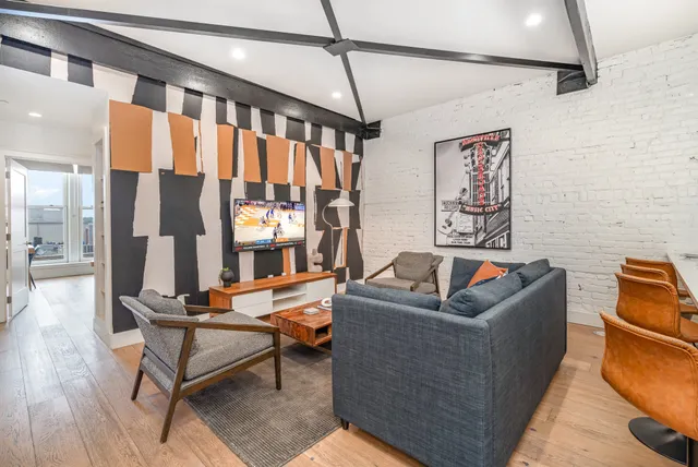 a living room with furniture and a floor to ceiling window