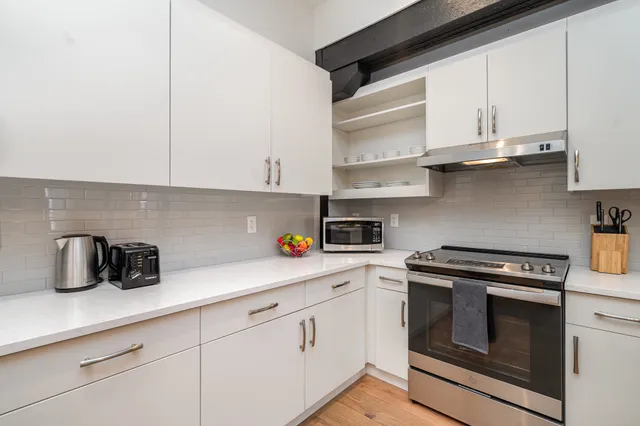 a kitchen with white cabinets and appliances