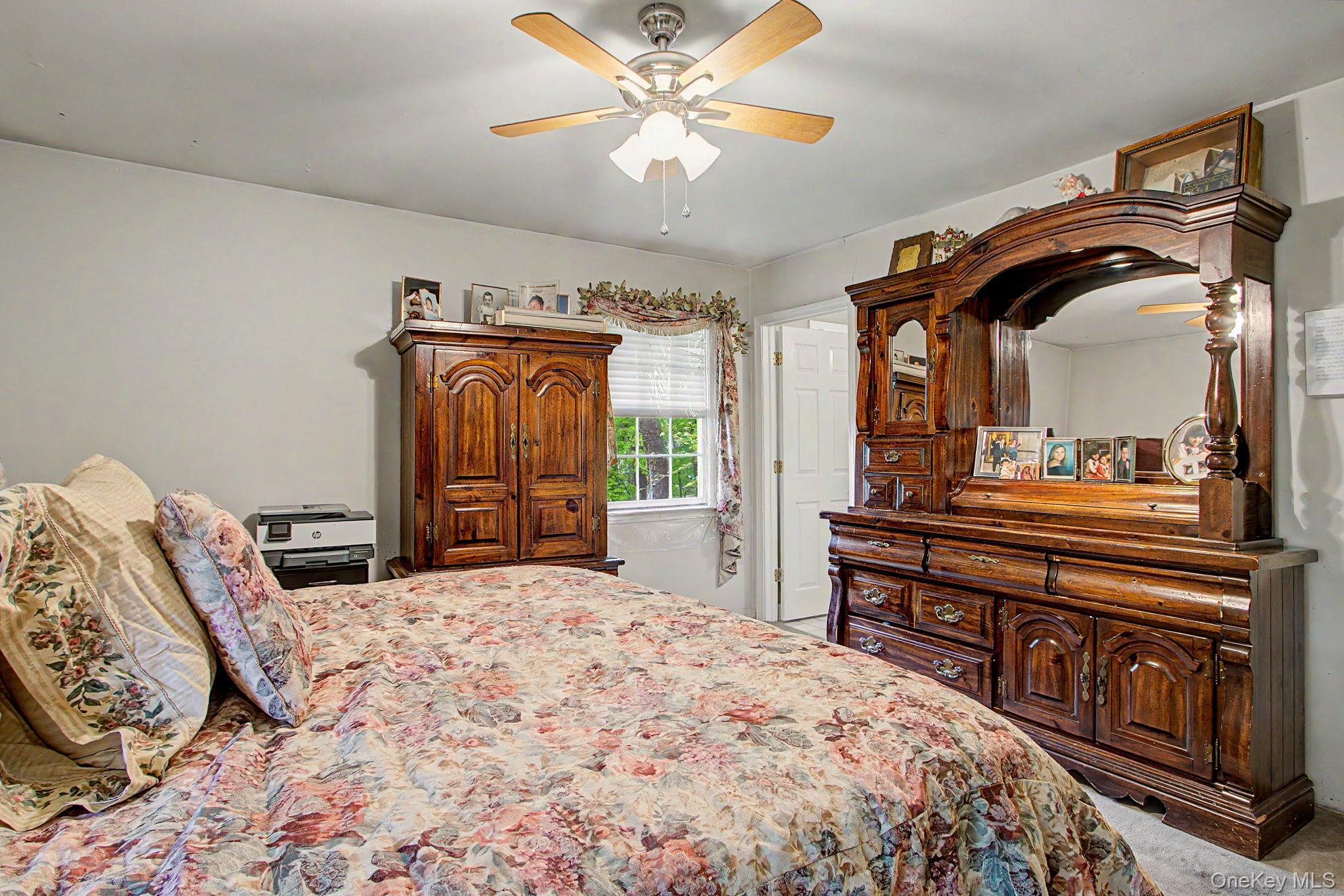 26 Garden Road Mahopac, NY 10541 - Photo 13 of 30 a bedroom with a bed a dresser and potted plants