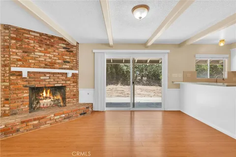 a view of empty room with wooden floor and fireplace